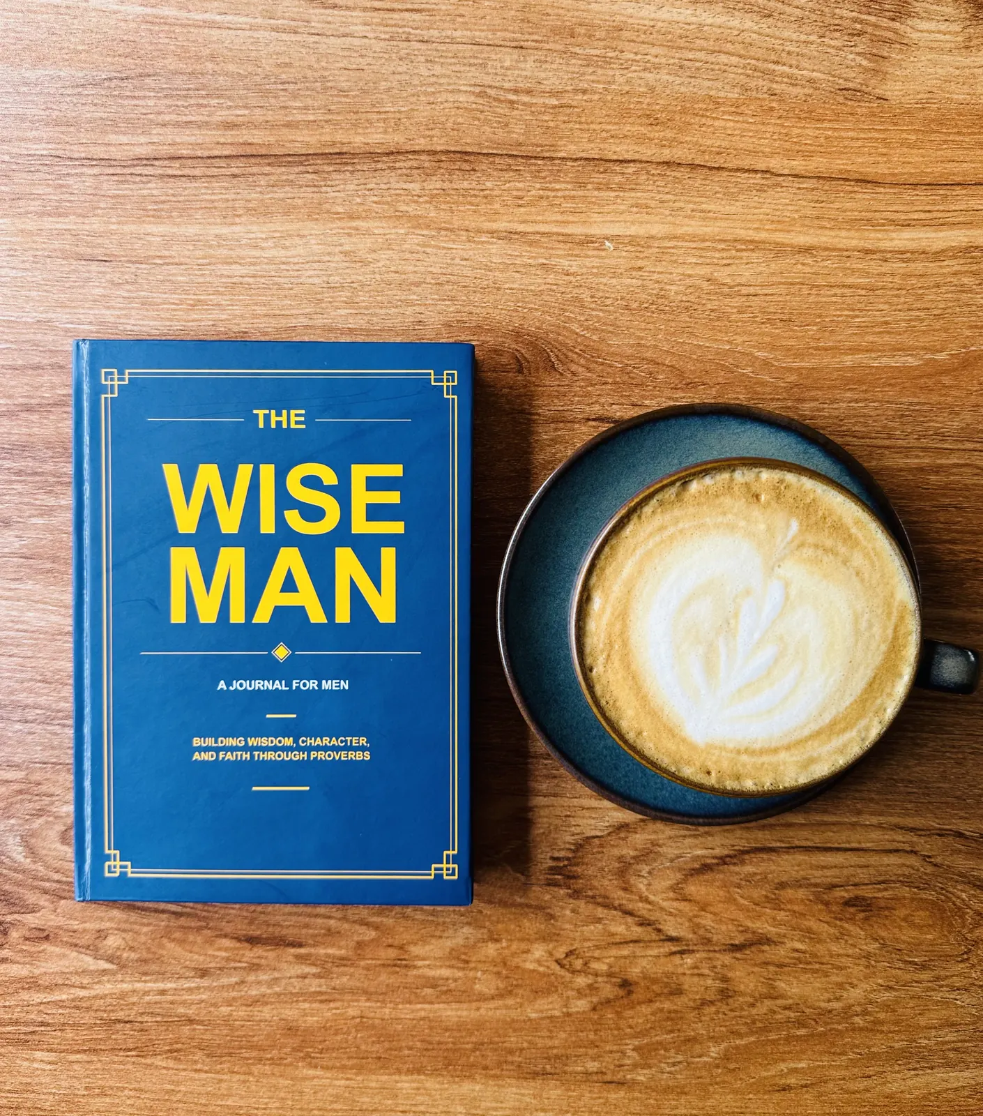 The Wise Man Journal beside a cup of coffee